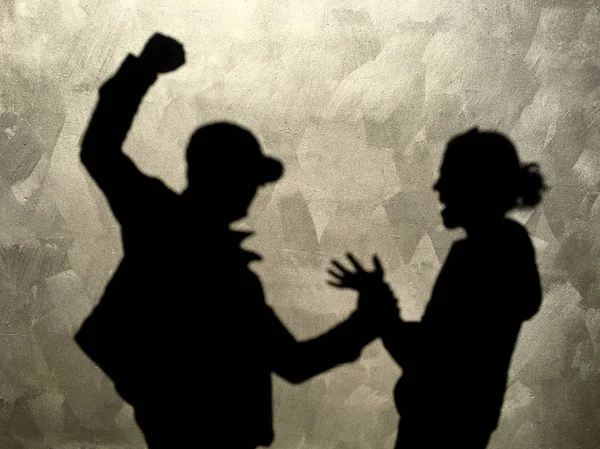通りの罪のない女性を打撃攻撃的な男の壁にシルエット影 — ストック写真