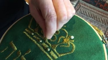 Kadın nakış evde. Nakış kumaş veya iş parçacığı veya iplik uygulamak için bir iğne kullanarak diğer malzemeleri dekorasyon zanaat olduğunu. Yakın çekim detayları.