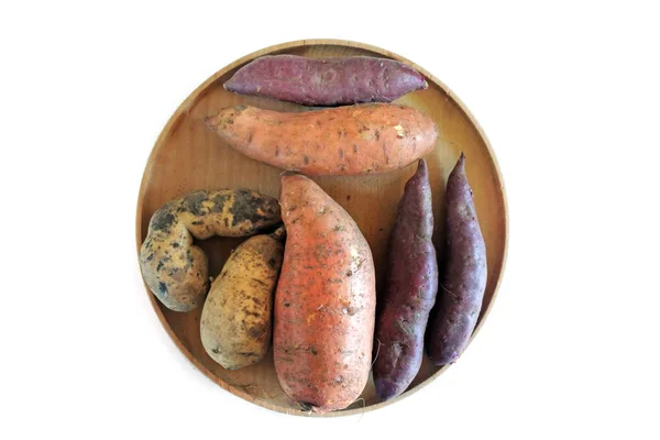 白い背景に分離された木製丸皿にサツマイモ根野菜選択のフラット レイアウト ビュー 食品の背景のテクスチャ コピー スペース — ストック写真