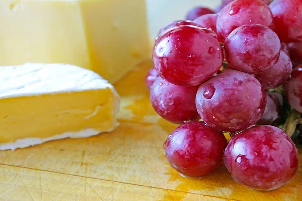 新鮮な暗闇の中にブドウの木の板にチーズ添えを読むをクローズ アップ 食品の背景のテクスチャ コピー スペース — ストック写真