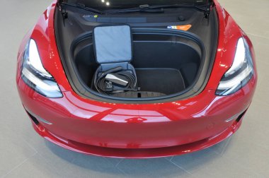 Ön kaput depolama alanı ve eklenti elektrikli otomobil Tesla Model 3, imal ve Tesla, Inc tarafından satılan bir orta boy / kompakt executive lüks dört kapılı sedan, elektrik kablo.