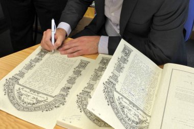 Auckland - Ekim 31 2018:Rabbi hak ve sorumlulukları ile ilgili olarak gelin damadın özetliyor bir geleneksel Yahudi evlilikte Ketubah Yahudi Prenuptial anlaşma Belge imzalama.