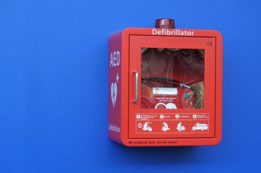 Kırmızı kutu defibrilatör kabine mavi bir duvar. Her yıl Avustralya'da yaklaşık 30.000 kişi ani kalp durması dışında hastane ortamlarında tarafından vurdu.