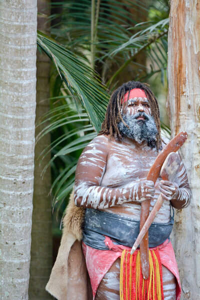Adult Indigenous Australianman holding boomerangs in Queensland, Australia.