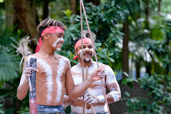 Happy Indigenous Australians men hunting in a rain forest Queensland, Australia.