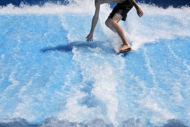 Gold Coast, Avustralya - Aralık 201 2018:Young adam flowriding ve yapay yaprak dalgalar üzerinde flowboarding. Yukarıya ve yere okyanus dalgaları şeklinde çoğaltmak için tasarlanmış yüzeyler su akar.