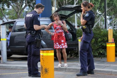 Brisbane - Aralık 25 2018:Australia polis memurları Brisbane, Avustralya bir Merry Christmas kıyafet giyen bir kadın soru.