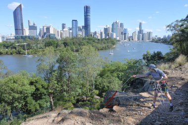 BRISBANE - JAN 16 2019:Young Australian man abseiling from a cliff in Kangaroo point in Brisbane Queensland, Australia.