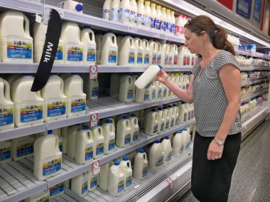 Gold Coast - 29 Ocak 2019:Woman bir süpermarkette Avustralya süt alıyor. Avustralya süt çiftçilerin süt yılda 9,102 milyon litre süt üretimi 4 milyar dolarlık varlık değeri üretmek.