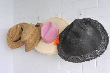 Erkek ve kadın tatil hasır şapkalar bir yaz evinde bir duvara asmak