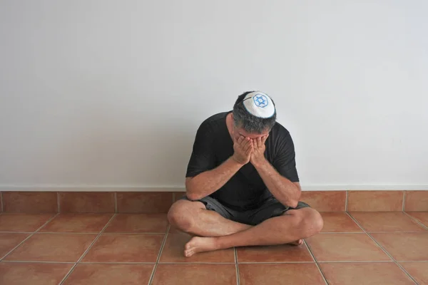 シヴァ 亡くなった第一度親類のユダヤ教の一週間にわたる喪の期間の間に彼の家の地面に座っているユダヤ人の男 — ストック写真