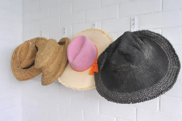 夏の家の壁にハングアップする男性や女性休日麦わら帽子 — ストック写真
