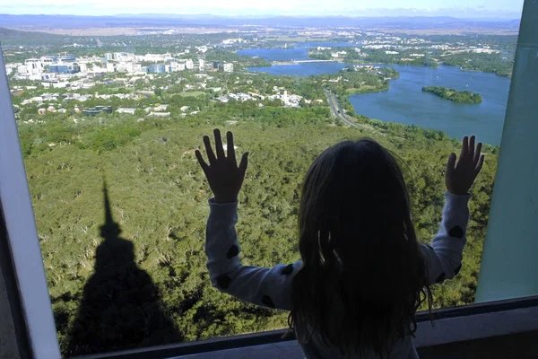 Junges Mädchen blickt aus dem Fenster auf Canberra, die Hauptstadt — Stockfoto
