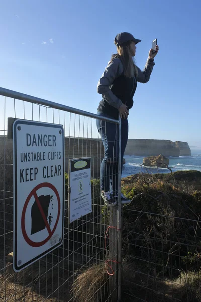 Toerist op zoek naar selfies negeren waarschuwingsborden zetten levens op r — Stockfoto