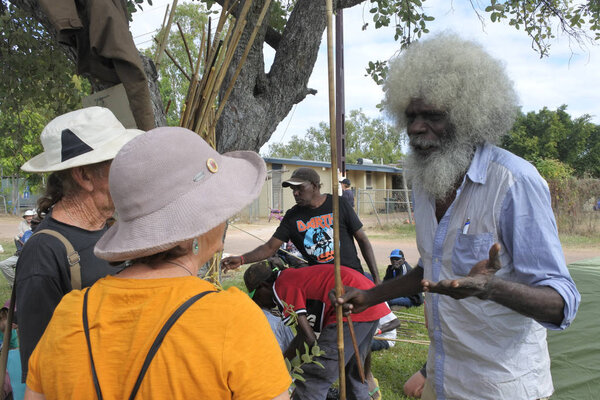 Indigenous Australians aboriginal man telling tourists about his