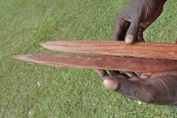 Indigenous Australians aboriginal craftman making a  a wooden Au