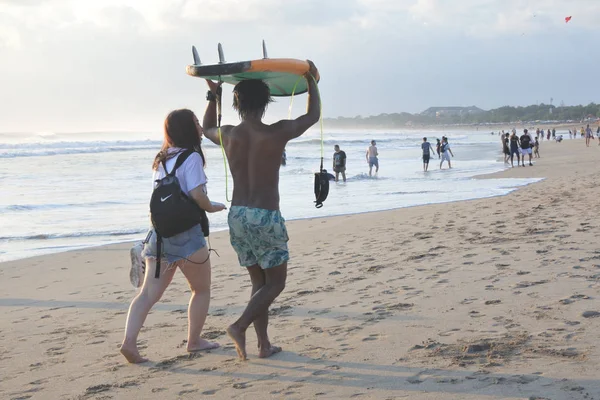 Japanese woman and Balinese male gigolo walking on Kuta beach in — Stock Photo, Image