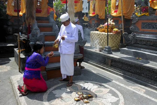 Hindu-Priester segnet balinesische Familie, die Galungan Kunin feiert — Stockfoto
