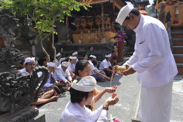 Sacerdote indù che benedice la famiglia balinese festeggiando Galungan Kunin — Foto Stock