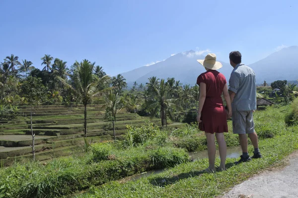 Tourist couple looking at the landscape view of rice fields in J — Stock Photo, Image