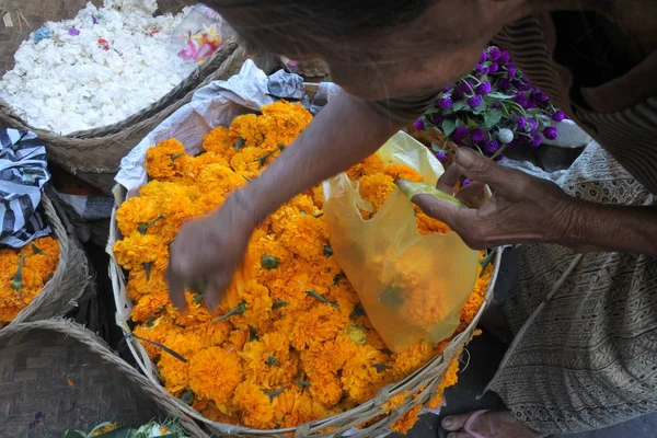 Balinese vrouw kopen Goudsbloem bloemen voor het aanbieden in Ubud Mark — Stockfoto