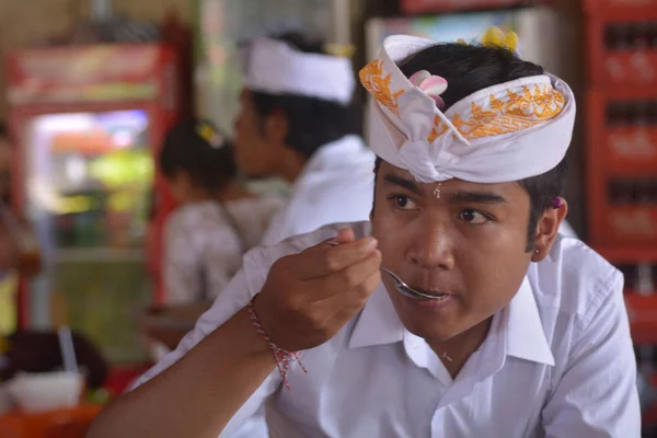 2019 レストランで食べ物を食べる伝統的な服を着たヒンドゥー教のインドネシア人男性 インドネシアの2018年の男性の平均余命は67歳の最新のWhoデータによると — ストック写真