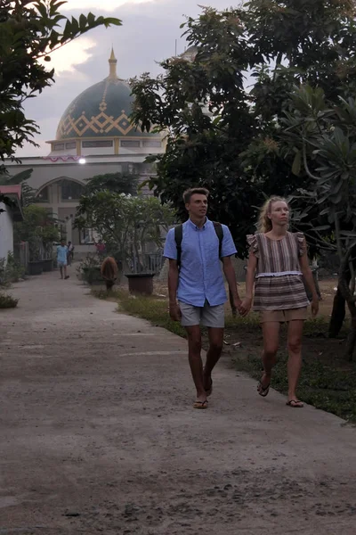 Toeristen wandelen in de buurt van een moskee in Gili Air eiland Indonesië — Stockfoto