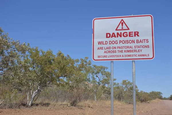 Надпись на дорожном знаке: Danger Wild dog poison baits — стоковое фото
