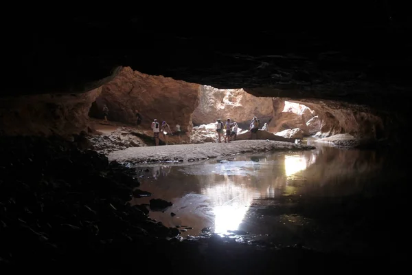 Pessoas irreconhecíveis caminhando na caverna subterrânea — Fotografia de Stock