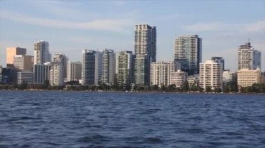 Batı Avustralya 'daki Swan River' dan gün batımında Perth City finans merkezi ufuk çizgisi manzarası.