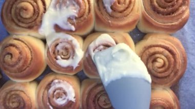 Kişinin bakış açısı mutfakta tarçınlı kurabiye üzerine krema eklemek.