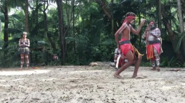 Avustralya 'nın Queensland şehrinde didgeridoo müzik aleti eşliğinde dans eden yerli Avustralyalılar.