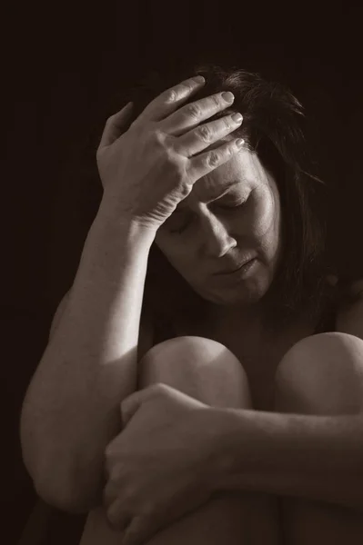 Расстроенная Взрослая Женщина Сидит Темноте Держа Голову Изолированной Черном Фоне — стоковое фото