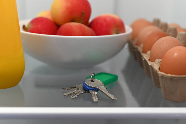 Home keys left inside a fridge beside food products by a person who suffering from memory loss.
