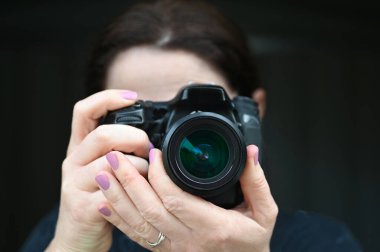 Siyah arka planda izole edilmiş bir kamerayla kadın fotoğrafçı..