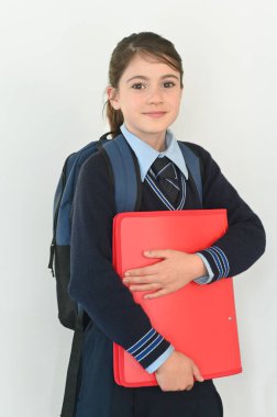 Okul üniformalı genç bir kız (10 yaşında) okul çantası taşıyor ve okula gitmeye hazır..