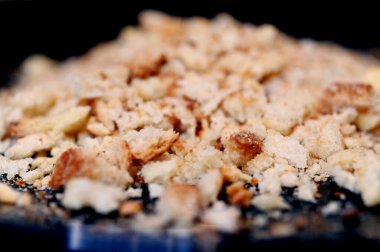 Siyah bir tabakta ekmek kırıntılarını kapat.