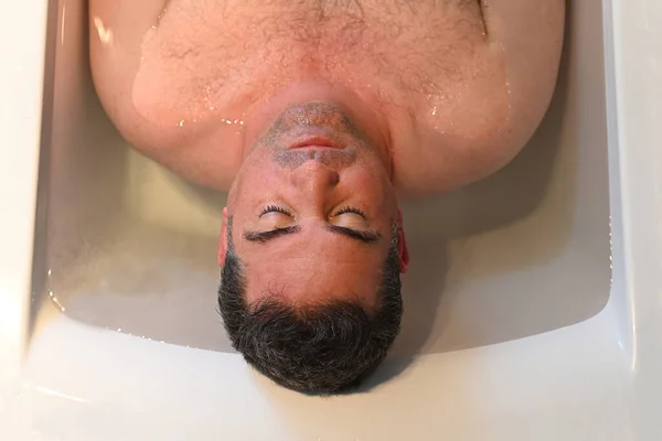 カメラを眺めながら入浴する大人の男 50歳 — ストック写真