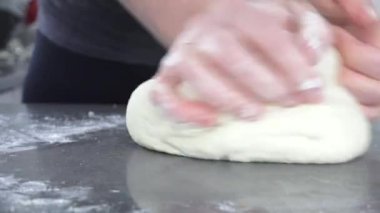 Hamur yoğuran kadın çok yakından bakıyor. 