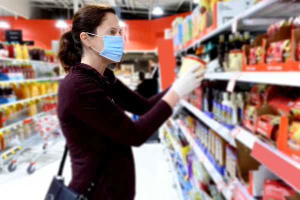 若い大人の女性 顔マスクを身に着けていると使い捨ての保護手袋スーパーマーケットで食料品店をやって — ストック写真