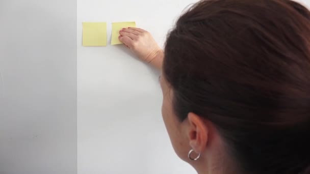 Genç Bir Kadını Yaş Duvara Yapışkan Notlar Yapıştırıyor — Stok video