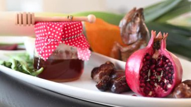 Yahudi kadın eli, Rosh Hashanah 'ın (Yahudi Yeni Yılı) yeni yıl yemeği tabağına taze kırmızı elma ekliyor. İnsan yok. Boşluğu kopyala