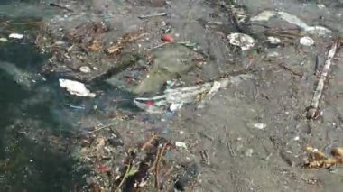 Çöp ve çöp suyun yüzeyinde yüzüyordu. Deniz yüzeyinde kirli ve plastik atık yüzen su kirliliği 