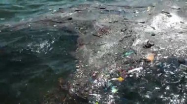 Çöp ve çöp suyun yüzeyinde yüzüyordu. Deniz yüzeyinde kirli ve plastik atık yüzen su kirliliği 