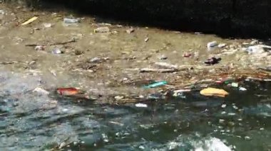 Çöp ve çöp suyun yüzeyinde yüzüyordu. Deniz yüzeyinde kirli ve plastik atık yüzen su kirliliği 