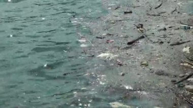 Çöp ve çöp suyun yüzeyinde yüzüyordu. Deniz yüzeyinde kirli ve plastik atık yüzen su kirliliği 