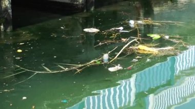 Çöp ve çöp suyun yüzeyinde yüzüyordu. Deniz yüzeyinde kirli ve plastik atık yüzen su kirliliği 