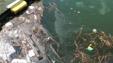 Çöp ve çöp suyun yüzeyinde yüzüyordu. Deniz yüzeyinde kirli ve plastik atık yüzen su kirliliği 