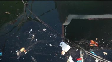Çöp ve çöp suyun yüzeyinde yüzüyordu. Deniz yüzeyinde kirli ve plastik atık yüzen su kirliliği 