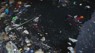 Çöp ve çöp suyun yüzeyinde yüzüyordu. Deniz yüzeyinde kirli ve plastik atık yüzen su kirliliği 